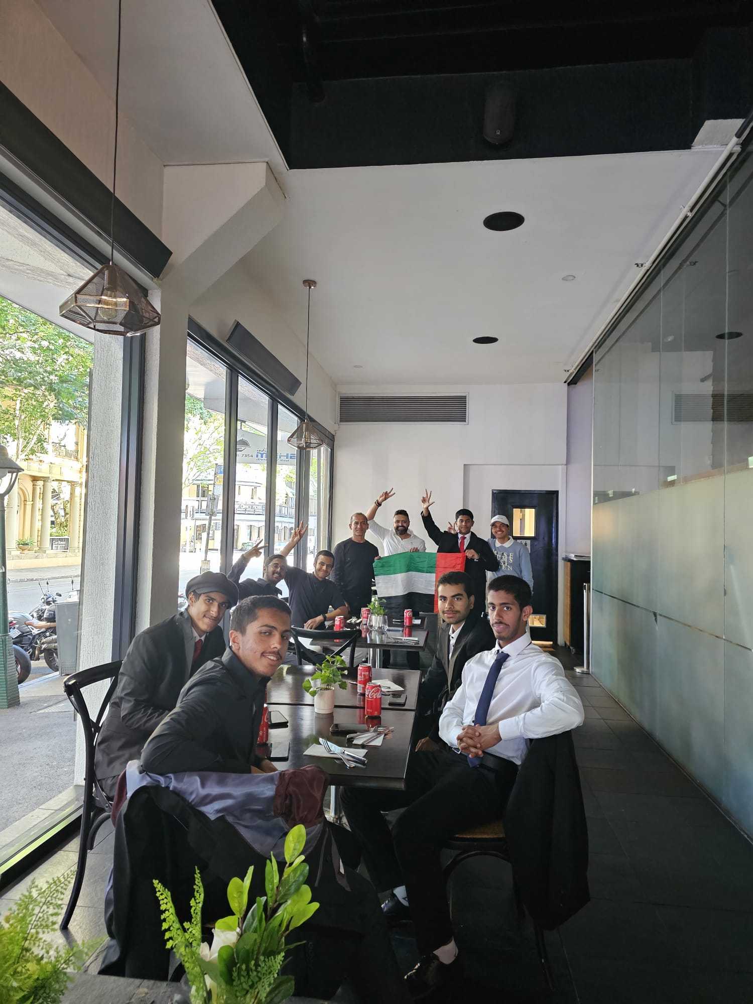 Guests gathered around a table by the street windows at Indian Mehek