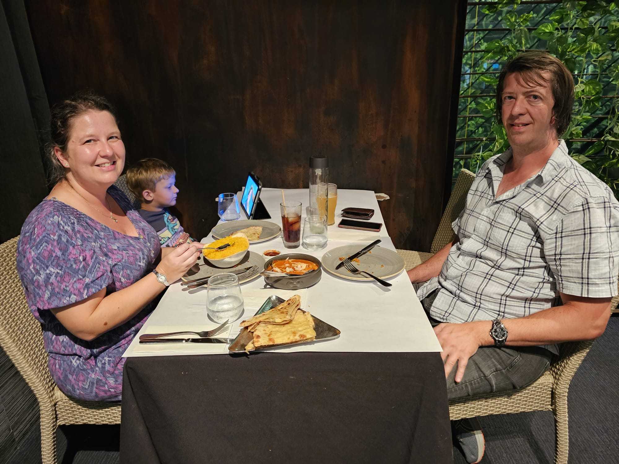 Guests sharing rice, bread, and curry at a table