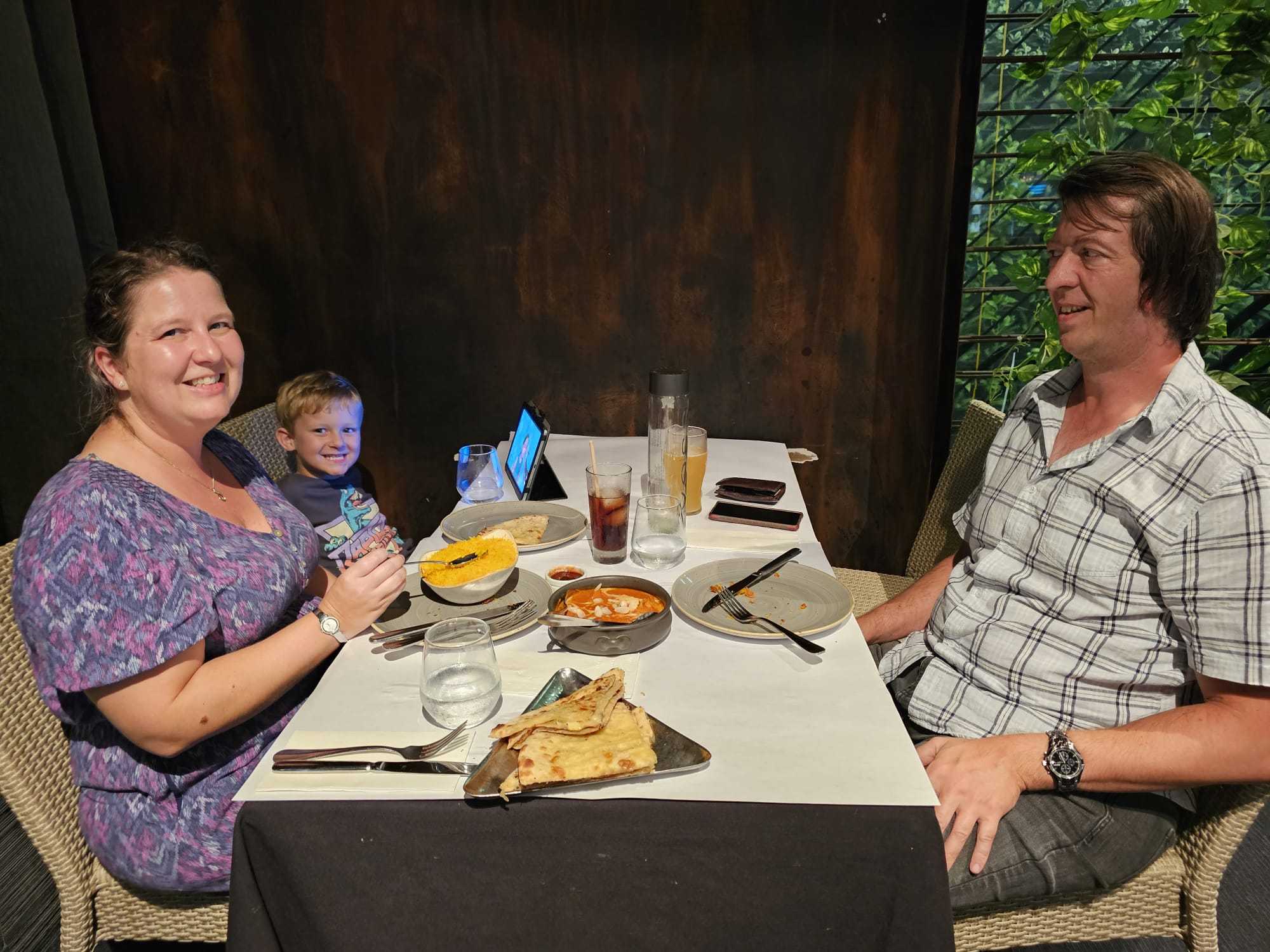 Guests at a table with bread, rice, and curry