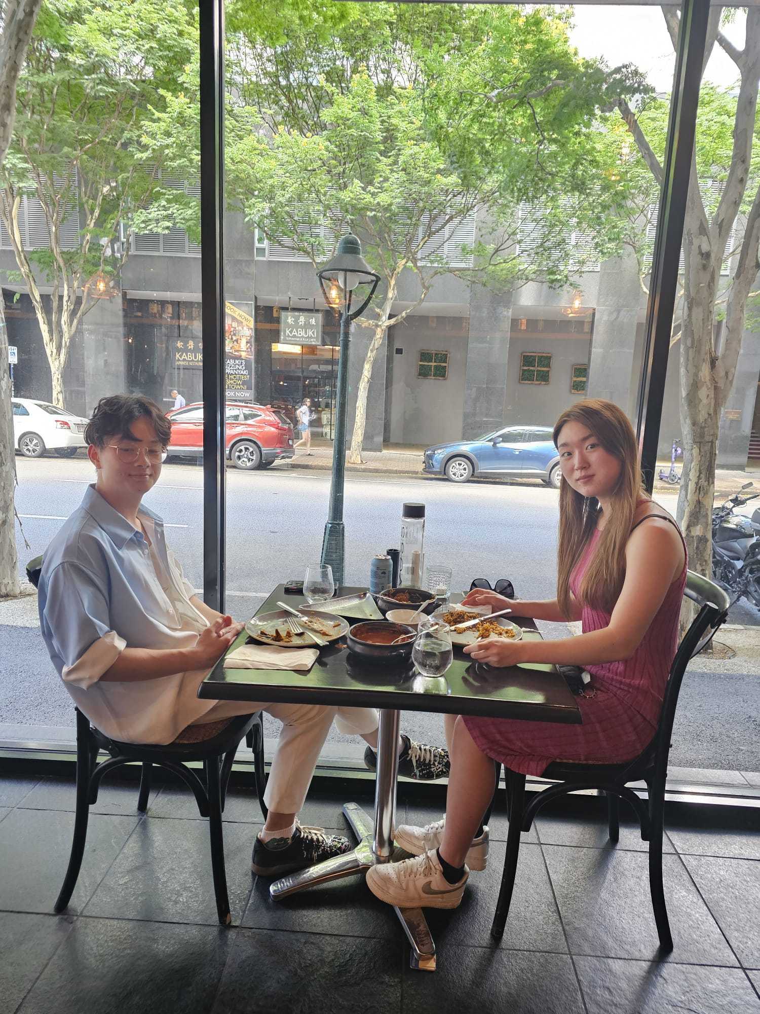 Two guests at a window table looking onto the Brisbane street
