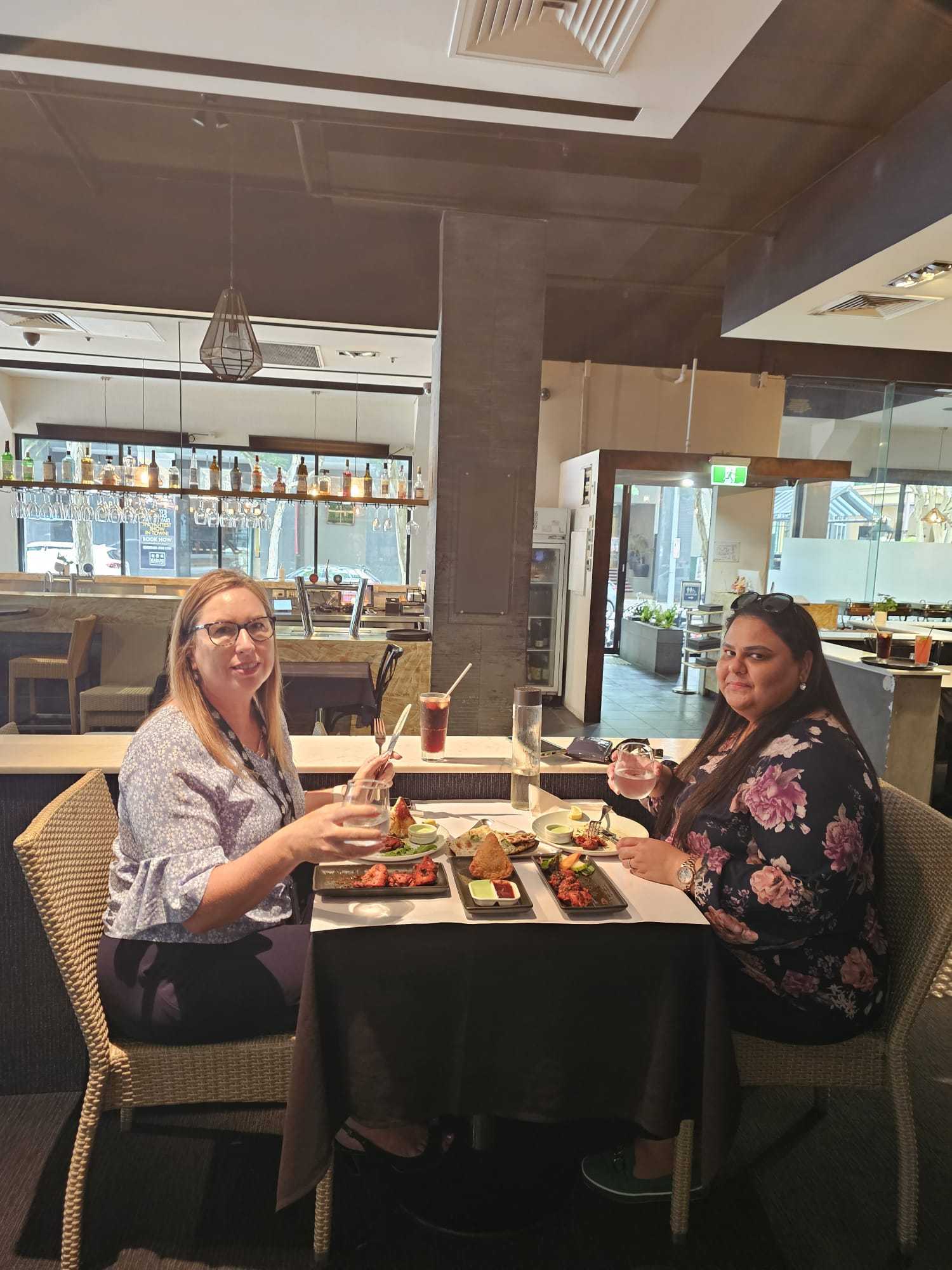 Two guests with starters and drinks at a table